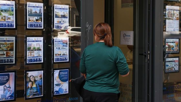 Una mujer revisa los carteles de una inmobiliaria