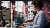 Una empleada trabajando con dos pantallas, en un call center