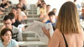 Una profesora de espaldas repartiendo un examen de selectividad