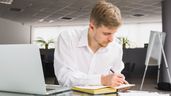 Trabajador escribiendo en papel. 