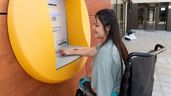Mujer con incapacidad saca dinero de un cajero automático
