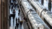 Viajeros caminando junto a trenes de Renfe