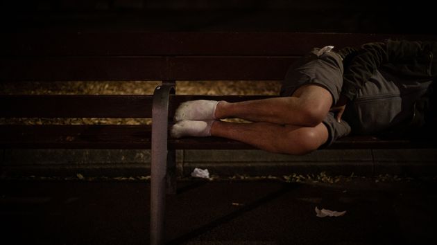 Un hombre durmiendo sobre un banco