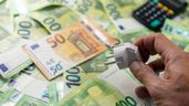 unos billetes de 100 euros un enchufe y una calculadora