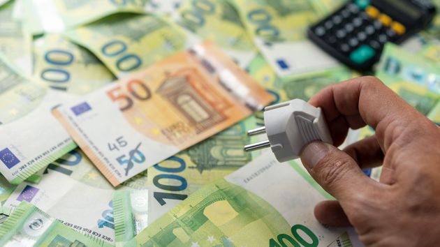 unos billetes de 100 euros un enchufe y una calculadora