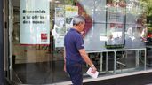 Hombre pasando delante de oficina de empleo