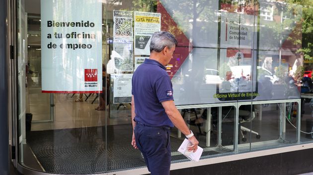 Hombre pasando delante de oficina de empleo