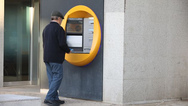 Un hombre saca dinero en un cajero automático