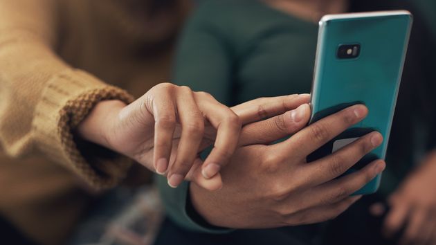 Dos personas mirando mensajes en el móvil