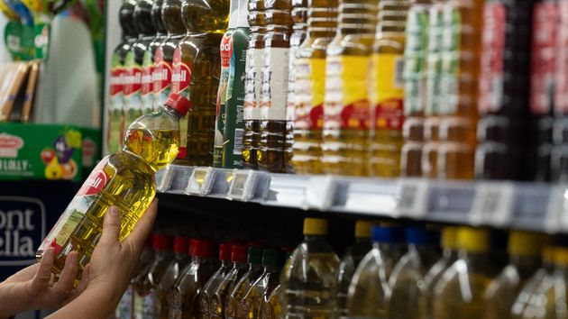 Una persona coge una botella de aceite