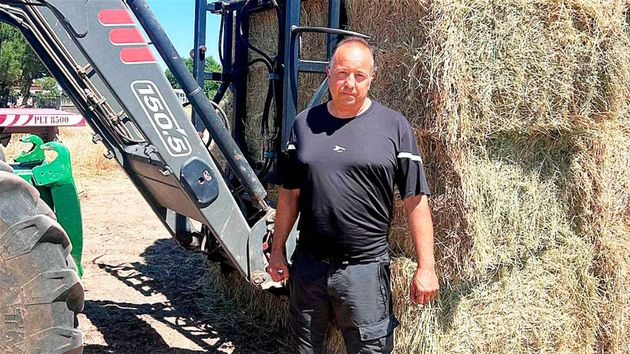 el agricultor junto a un montón de paja