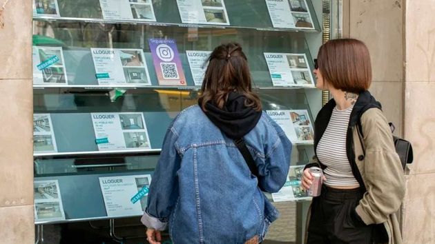Dos mujeres mirando carteles en una inmobiliaria