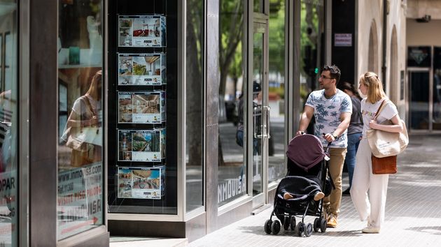 Dos personas aleatorias mirando los anuncios de una inmobiliaria