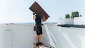Un hombre tirando un mueble desde la terraza 