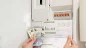 unas facturas de la luz e, un contador y billetes de euros