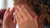 Una mujer, emocionada, tapándose la cara con las manos