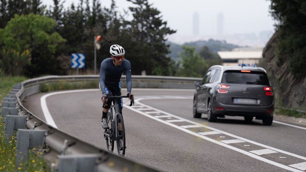 Una bicicleta y un coche circulan por la carretera de l’Arrabassada