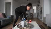 Una trabajadora doméstica aleatoria realiza tareas del hogar en una casa particular, 