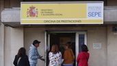 Varias personas en la entrada de una oficina del SEPE
