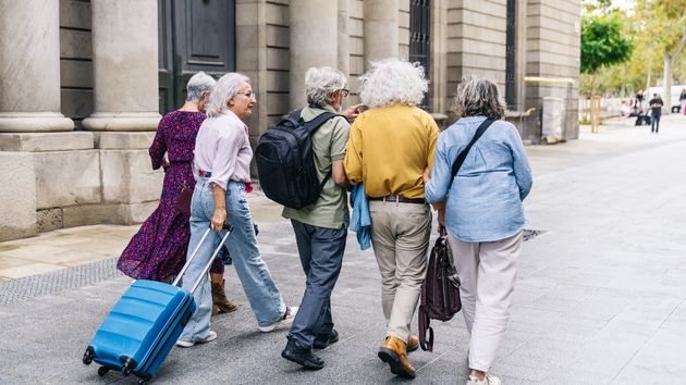 Jubilados con maletas por la calle.