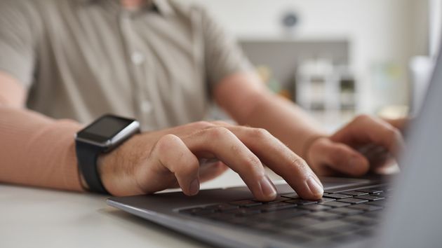 Un trabajador escribiendo en el ordenador