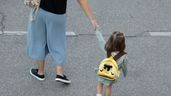 Una madre llevando a su hija al colegio