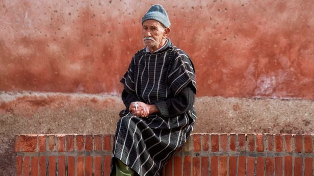 Hombre semtado en un muro