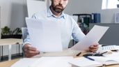 Un empleado leyendo varios documentos