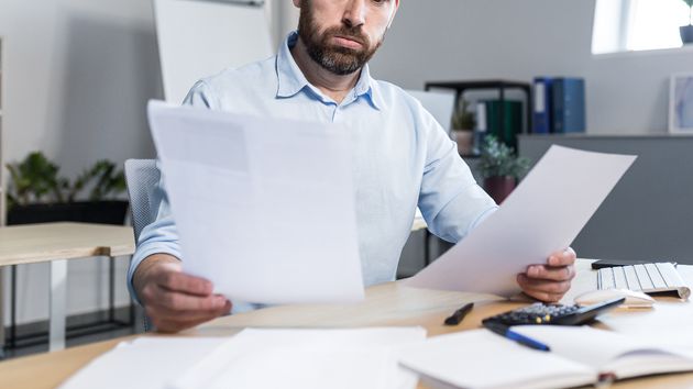 Un empleado leyendo varios documentos