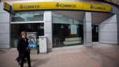 Mujer caminando por delante de una oficina de Correos