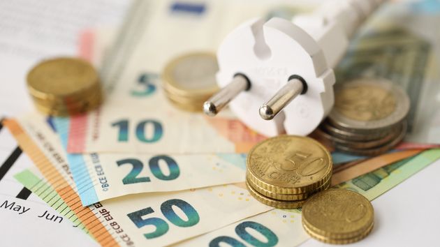 unos billetes de euros monedas y un enchufe