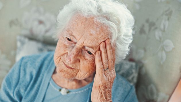 Mujer anciana con la mano en la cabeza