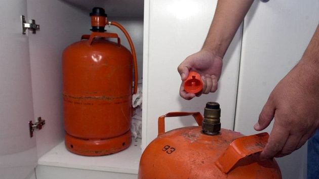 Una persona cambia una bombona de butano
