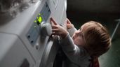 un niño enciende la lavadora