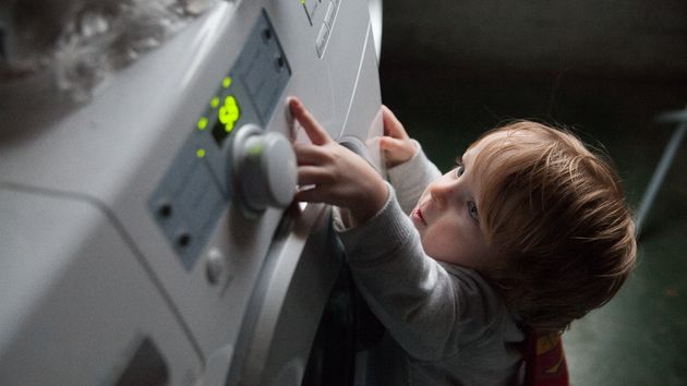 un niño enciende la lavadora