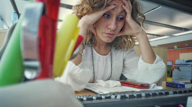 Una mujer aleatoria agobiada en su puesto de trabajo