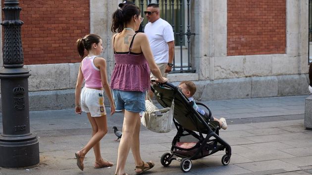 Una madre pasea con sus hijos