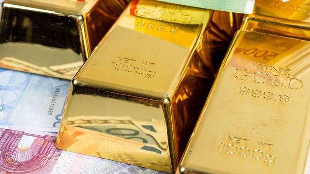 Lingotes de oro sobre billetes de euro