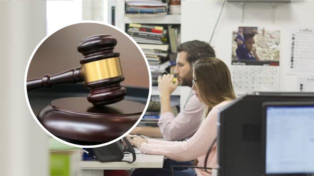 Dos empleados públicos junto al mazo de un juez