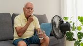 Un hombre con calor frente a un ventilador