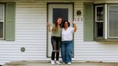 La joven junto a su abuela en la puerta de la vivienda 