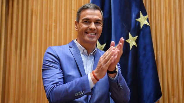 Pedro Sánchez sonriendo mientras aplaude