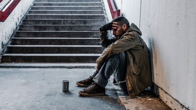 Hombre sin techo en pie escalera