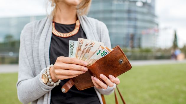Una mujer con dinero en la cartera 