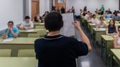 Un profesor aleatorio de espaldas mostrando un examen