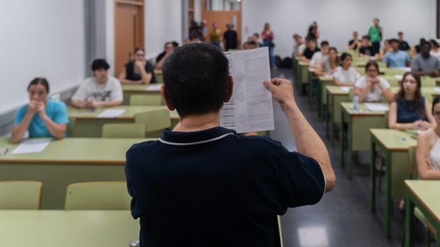 Un profesor aleatorio de espaldas mostrando un examen