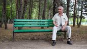 Un hombre mayor aleatorio sentado en el banco de un parque