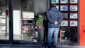 Hombre en un escaparate de inmobiliaria