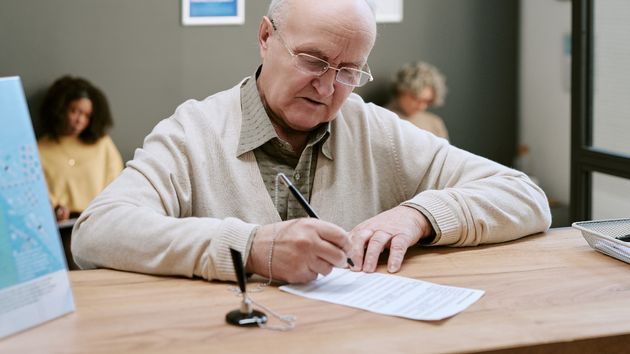 Imagen representativa de un hombre firmando un documento 