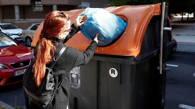 Una mujer tirando la basura